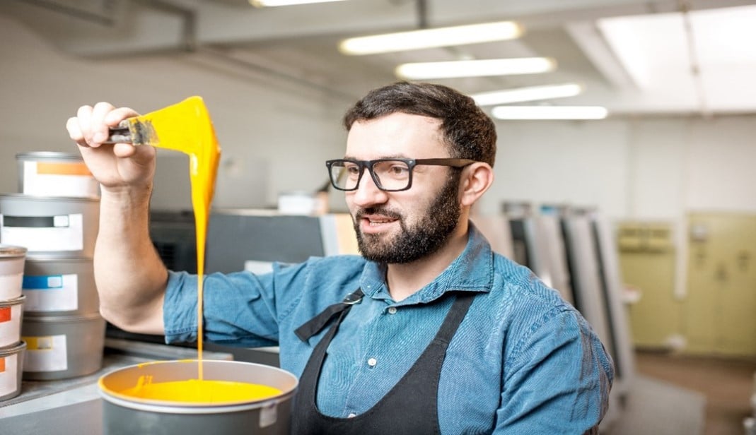Revolutionieren Sie Ihr Projekt mit professionellen Lackierlösungen 3 Person mit gelbem Farbeimer in der Hand