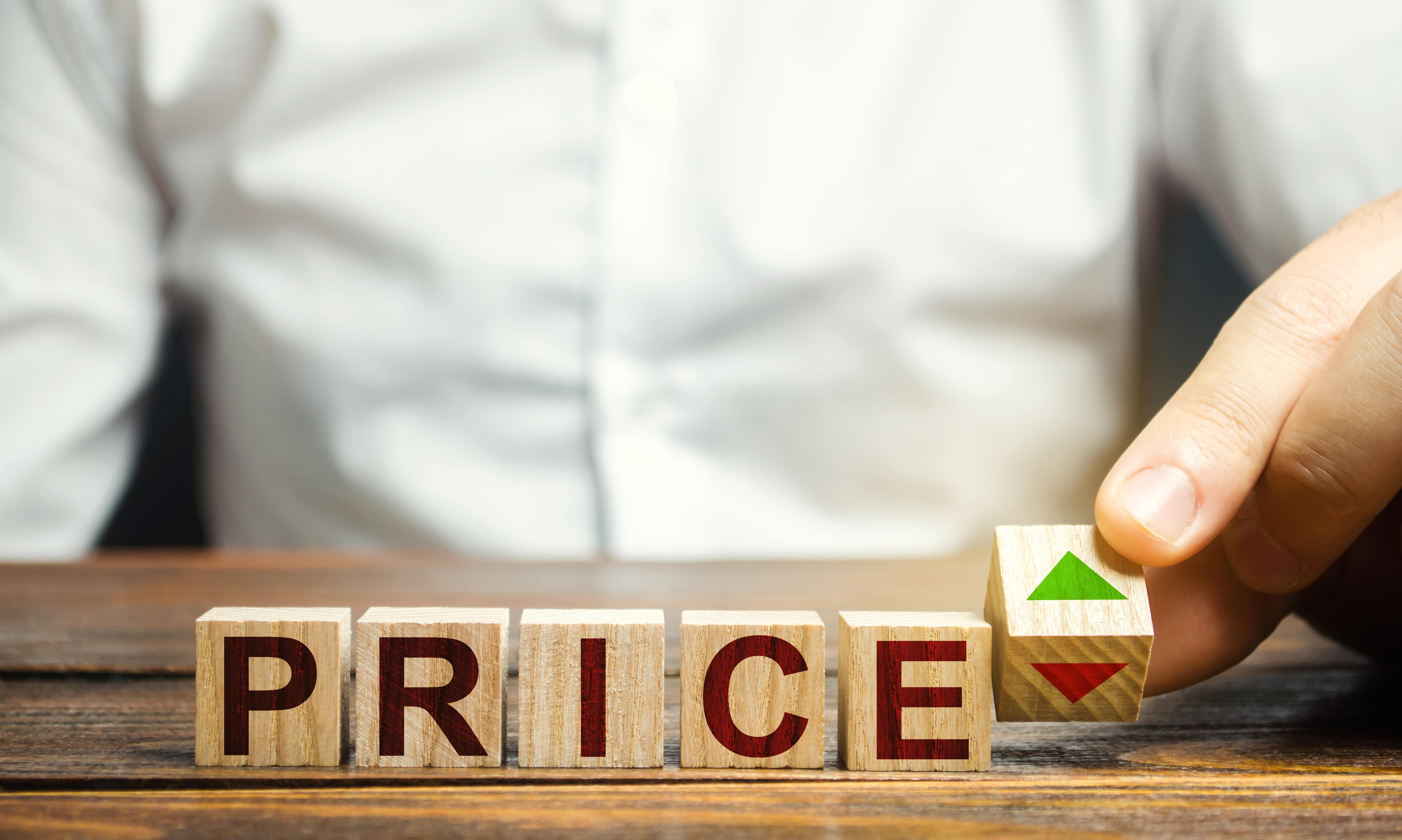 Inflation, und wie kann man sich davor schützen? 2 Holzwürfel, die nebeneinander gereiht sind, und zusammen das Wort Preis ergeben