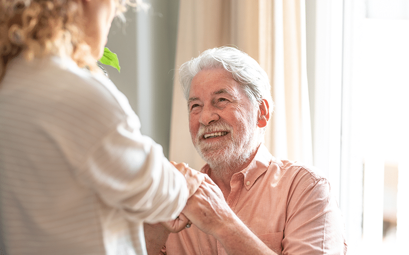 Pflegenotstand in Deutschland 2 Fröhlicher Renter lächelt Pflegekraft an
