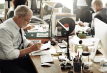 Älterer Arbeitnehmer sitzt an einem Schreibtisch im Büro und arbeitet an Unterlagen, passend zum Thema Aktivrente 2026 und Weiterarbeit nach Erreichen der Regelaltersgrenze.